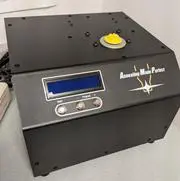 A black box with a yellow button on top of it.