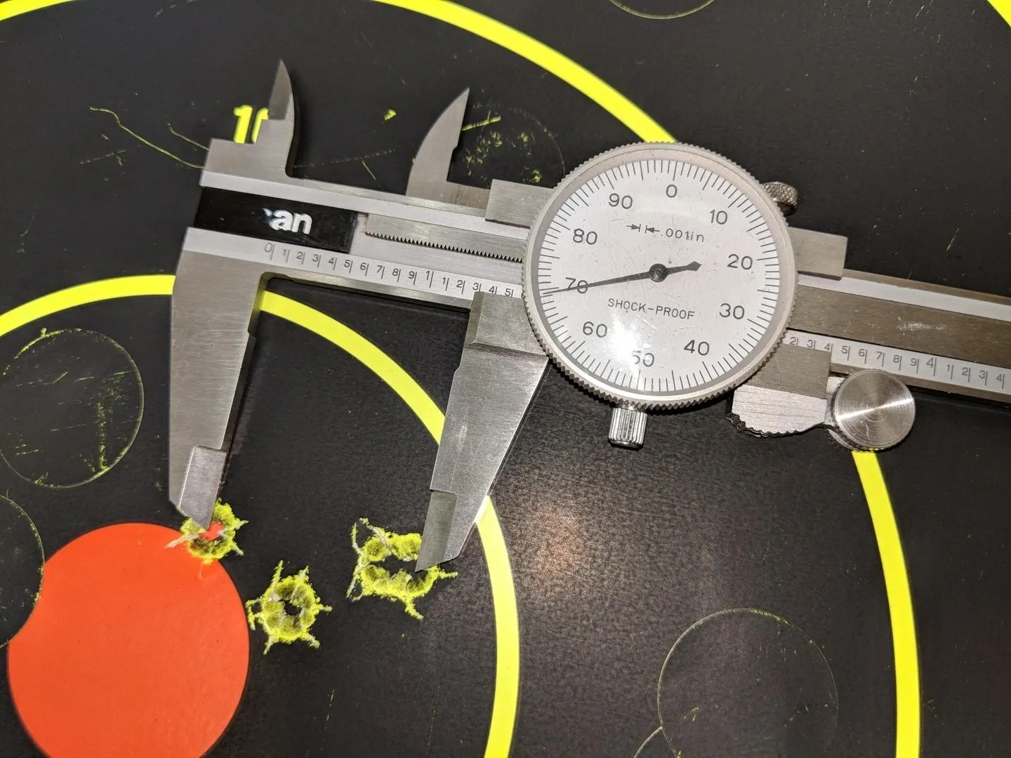 A metal measuring instrument with some orange and yellow objects on it